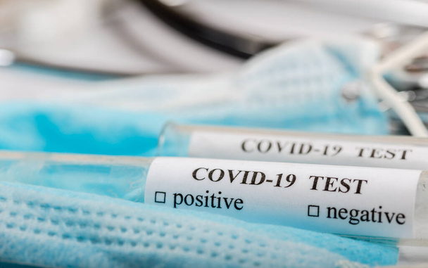 Concepto de prueba del Coronavirus COVID-2019 con tubos de análisis de sangre, forma de prueba y otros objetos médicos
 - Foto, Imagen