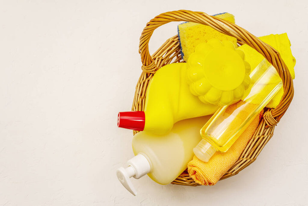 House cleaning product in basket. Spray, bottle, soap, dishwashing sponge, duster, gel air freshener. Home disinfection in quarantine. White putty background - Photo, Image