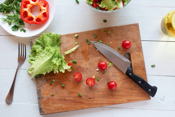 El proceso de hacer ensalada en casa sobre un fondo blanco. Vegetarianismo. Estilo de vida saludable
. - Foto, Imagen
