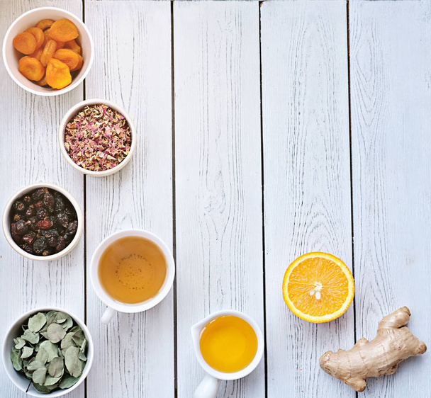 ingrediënten voor immuunversterkende thee- kruiden, gember, sinaasappel, honing en rozenbottels. - Foto, afbeelding