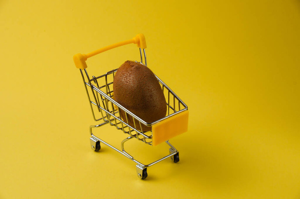 Kiwi sur fond jaune dans un chariot d'épicerie, vue du haut - Photo, image