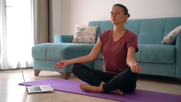 An attractive young woman doing meditation while working from home. - Footage, Video