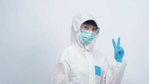 Asian doctor woman wear PPE suit or Personal Protective Equipment and medical mask and gloves which use for protect covid-19 virus pandemic from Wuhan China and talking about quarantine for safety - 写真・画像