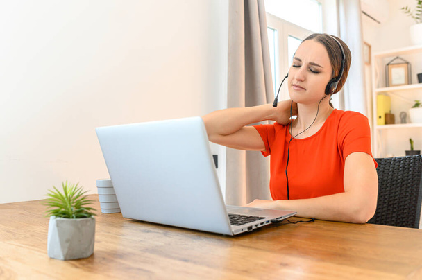 Woman works from home using headset and laptop - Foto, immagini
