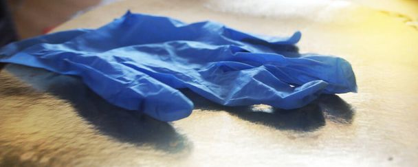 Rubber medische handschoenen, chirurgische handschoenen op gouden achtergrond. Concept voor de preventie van het coronavirus. - Foto, afbeelding
