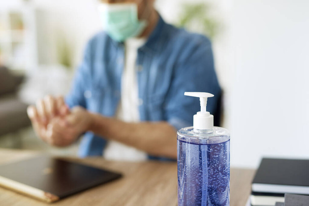 Detail van antibacteriële zeep en wazig werkende man - Foto, afbeelding