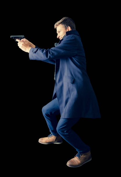 Вид сбоку на молодого копа в пальто и шарфе с пистолетом в руках. Целься. Специальная операция. Isolated
 - Фото, изображение