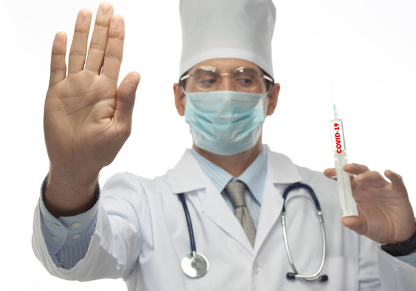 young caucasian man  doctor in uniform isolated on white  stethoscope with syringe for injection hand stop virus carantine coronavirus covid-19 - Φωτογραφία, εικόνα