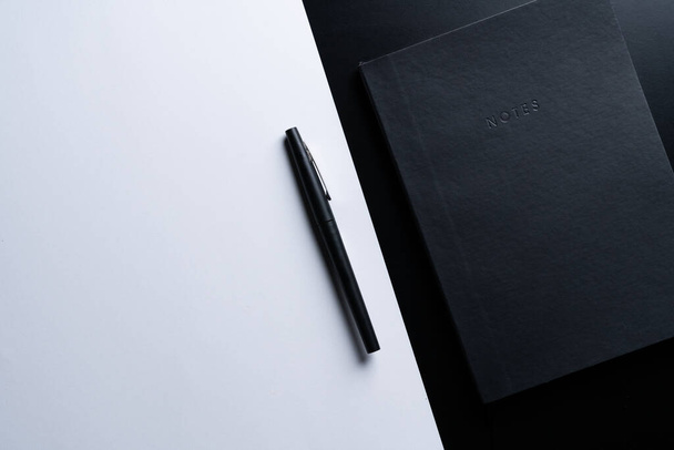 Black style set: notepad and pen on Black background. - 写真・画像
