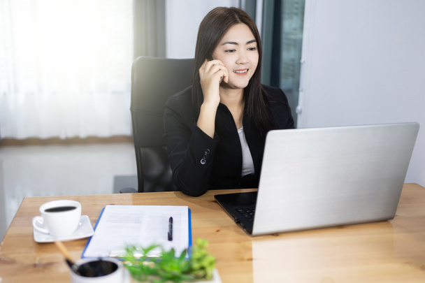 Work from home concept. Asian pretty bussiness woman using laptop and phone. - Foto, Bild