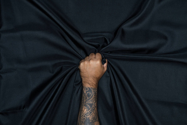 Paño de cortina negro abstracto, patrón y detalle ranurado de tela negra para fondo y abstracto a mano
. - Foto, imagen