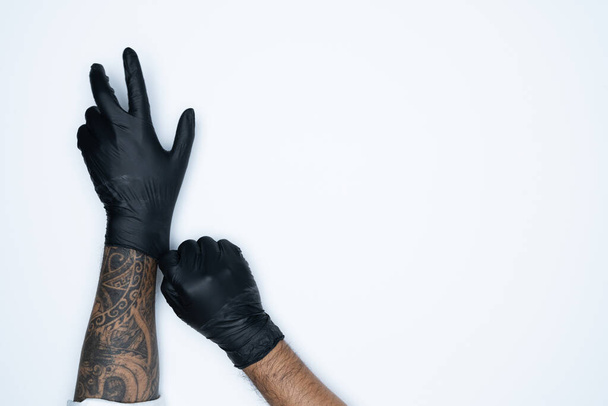 Muž s variací černé latexové rukavice, výroba gumových rukavic, lidská ruka má na sobě lékařskou rukavici, rukavici, izolovanou - Fotografie, Obrázek