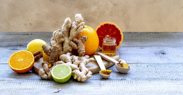 Composição com gengibre, mel, açafrão e laranjas como remédios frios naturais em fundo de madeira
. - Foto, Imagem