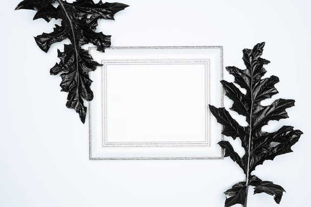 Üres (üres) fehér képkeret fekete levelek elszigetelt fehér háttér. - Fotó, kép