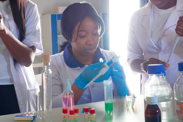 Тестовий центр. Молоді африканські жінки-вчені, медики або студенти-медики працюють разом, виконуючи кров, нуклеїнову кислоту, медичні тести в тестовій лабораторії для діагностики пацієнтів з пневмонією Ковід-19.. - Фото, зображення