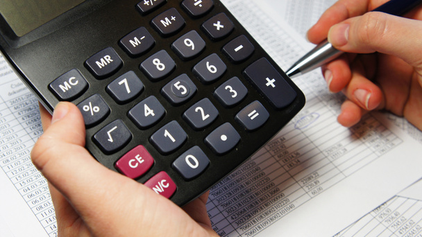 Calculadora, caneta e documento de contabilidade com um monte de números
  - Foto, Imagem