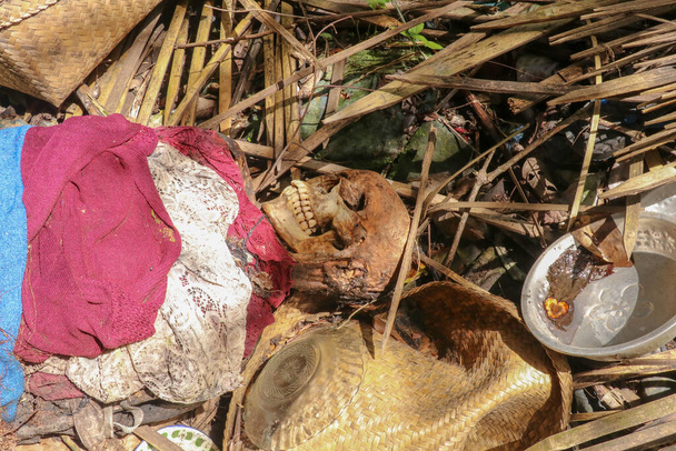 Primer plano del cuerpo del hombre muerto vestido con tela de colores acostado en el suelo, forma tradicional de entierro en Bali, Indonesia. Kuburan Terunyan Cemetery en Bali. Los cuerpos están enterrados sobre el suelo
. - Foto, Imagen