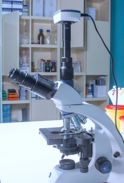 Lichte of fluorescerende stereomicroscoop in onderzoekslaboratoriumomgeving of histopathologieopleiding voor artsen, studenten of wetenschappers in de biologieles over trendy cyaanachtergrond - Foto, afbeelding