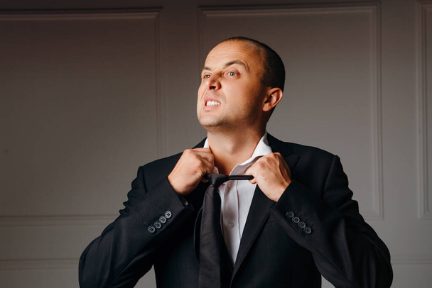 Hombre de negocios enojado quitándose la corbata
 - Foto, Imagen