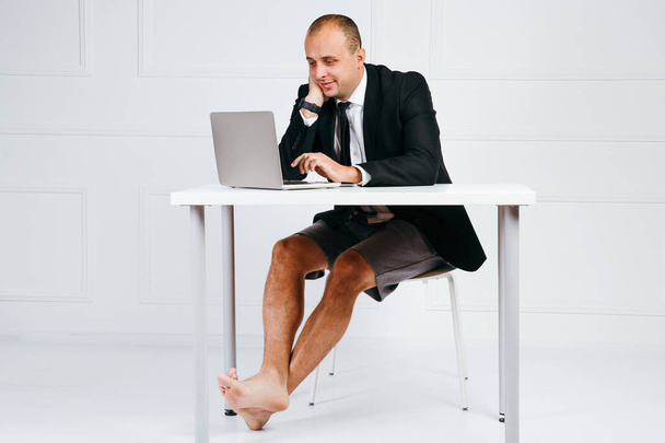 Empresário feliz em terno usando laptop no escritório
 - Foto, Imagem