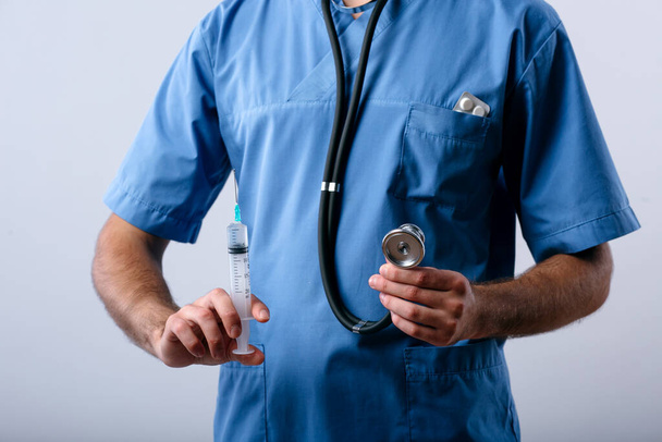 Closeup doctor intern holding syringe for injection and stethoscope isolated on white background - Fotografie, Obrázek