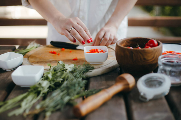 Frauenhände hacken Gemüse auf Holzteller. Gesunde vegetarische Kost - Foto, Bild