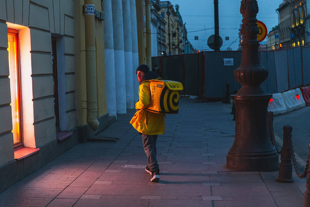Saint-petersburg, Russia - 31 March 2020: The courier is walking along the main street of the city. - Foto, imagen