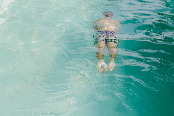 Boy swimming underwater in the pool in summer - 写真・画像