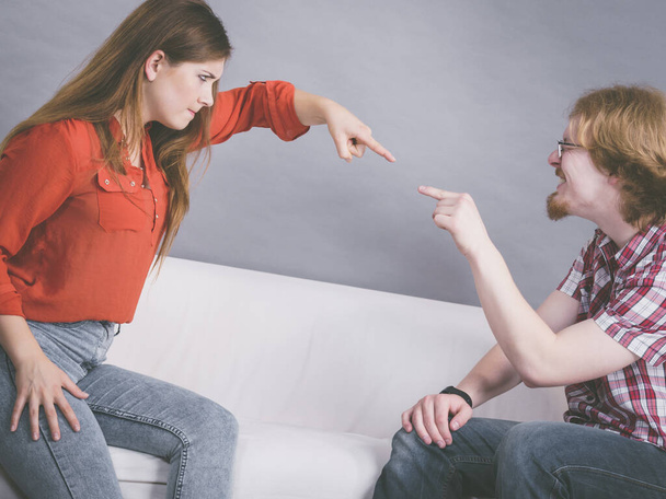 Man and woman having horrible fight while sitting on sofa. Friendship, couple breakup difficulties and problems concept. - 写真・画像