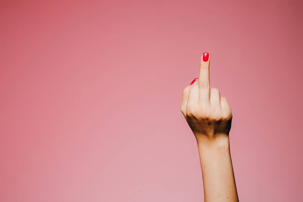 Frauenhände mit heller Maniküre auf rosa Hintergrund verschwinden - Foto, Bild