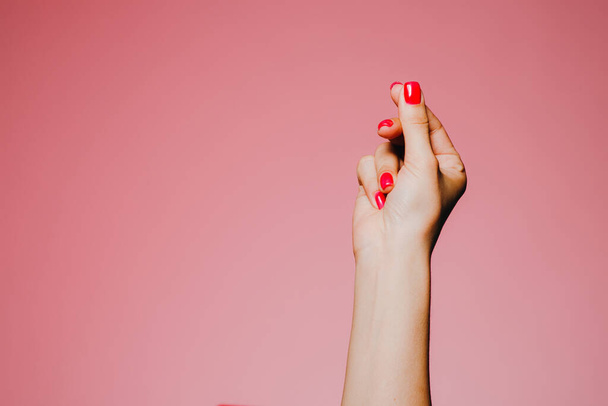Mão de encaixe da mulher com manicure brilhante isolado em fundo rosa
 - Foto, Imagem