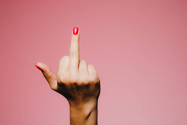 Woman's hands with bright manicure isolated on pink background go away sign - 写真・画像