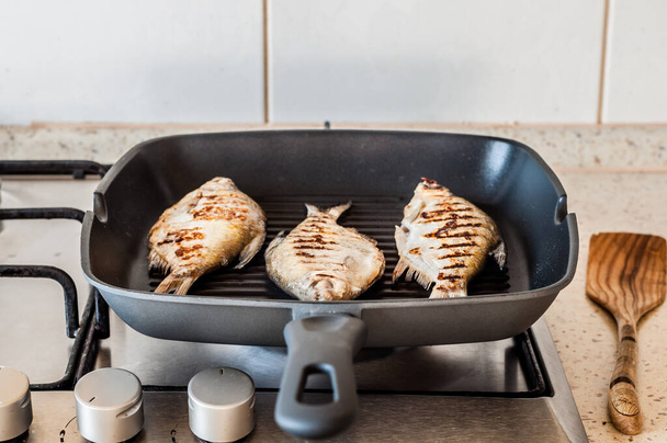 Grilling Breams in a Skillet on Gas Stove Top, copy space for your text - Foto, afbeelding