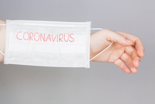 Romanzo coronavirus Maschera chirurgica maschera protettiva con testo CORONAVIRUS. Un'epidemia di coronavirus cinese. Maschera in mani donna
 - Foto, immagini