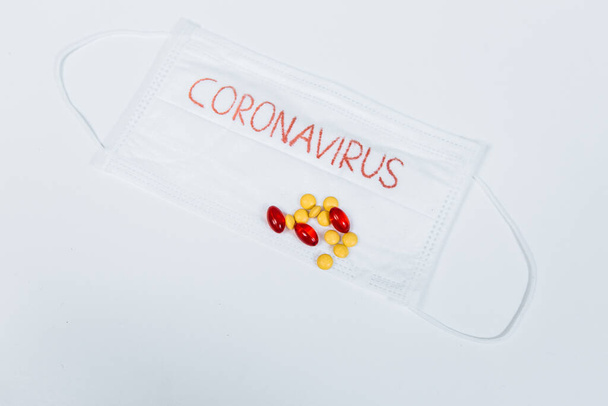 Mask with the inscription coronavirus and pills, syringes. Pandemic disease - Foto, Imagem