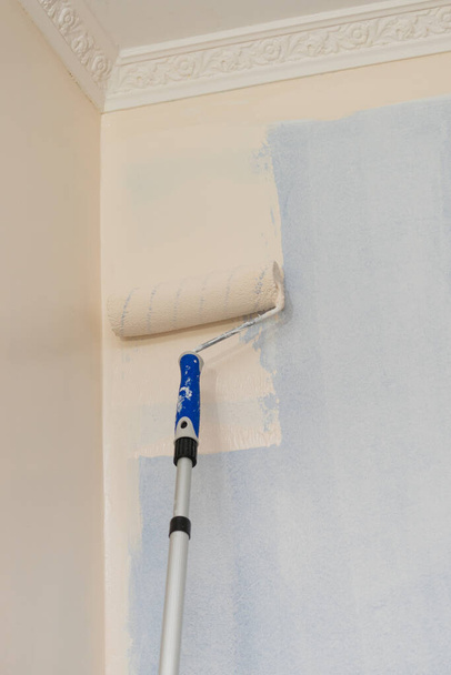 Person appplying paint on wall using roller brush. Home renovation concept. - Fotografie, Obrázek