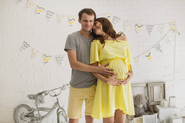 Pregnant woman with husband in the Studio. - Фото, зображення