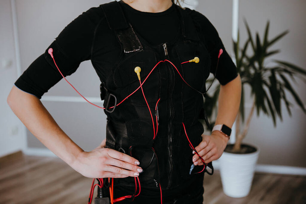 Žena v EMS elektro stimulační oblek s kabely. - Fotografie, Obrázek