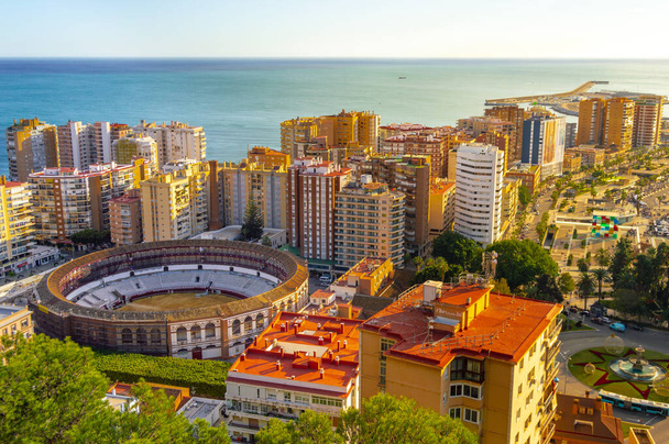 Aerial cityscape of Malaga center in Spain at sunset. View of sea, bullring, harbor and other tourist attractions. Landscape of Costa del Sol. - Photo, Image