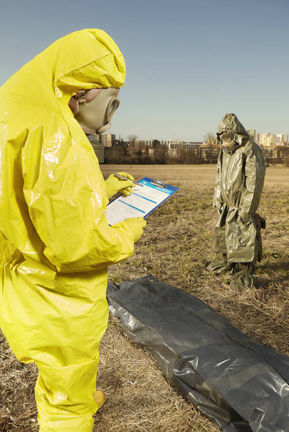 Team in protection suits pick up unknown victim of disease covid-19 - 写真・画像