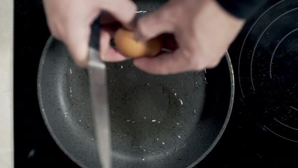 fried eggs cooked in a frying pan at home on the stove in sunflower oil - Materiał filmowy, wideo