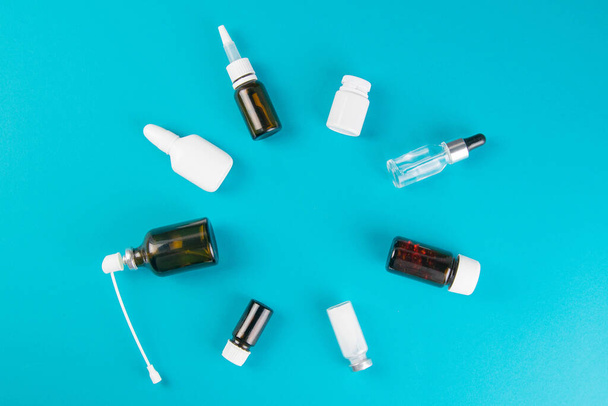 Different vials and sprays with medicines are laid out in the form of a circle. Top views with clear space. - Photo, Image