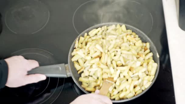 las patatas se cocinan en una sartén en casa en la estufa en aceite de girasol, patatas fritas en una sartén
 - Metraje, vídeo