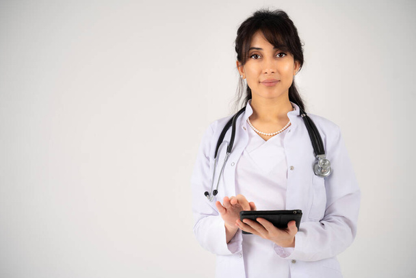 Młoda dziewczyna lekarz lub student stoi z tabletem w rękach - Zdjęcie, obraz