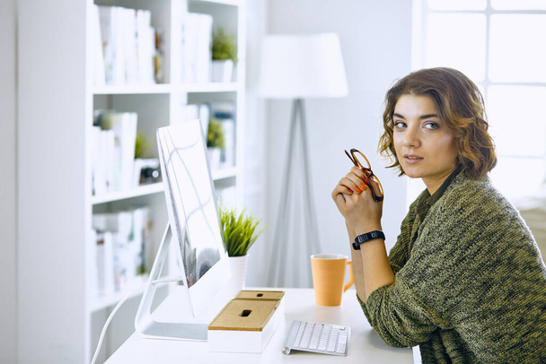 Mujer joven trabajando con tableta gráfica en la oficina
 - Foto, imagen