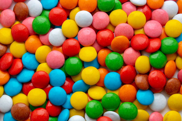 Фон маленьких разноцветных драже. конфеты сладкого цвета
 - Фото, изображение