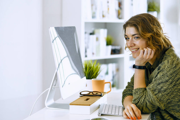 jonge vrouw die werkt met grafisch tablet in kantoor - Foto, afbeelding
