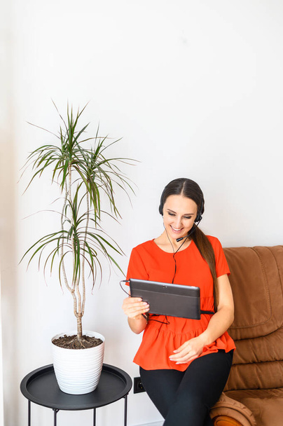 Young woman with hands free headset and tablet - Foto, imagen