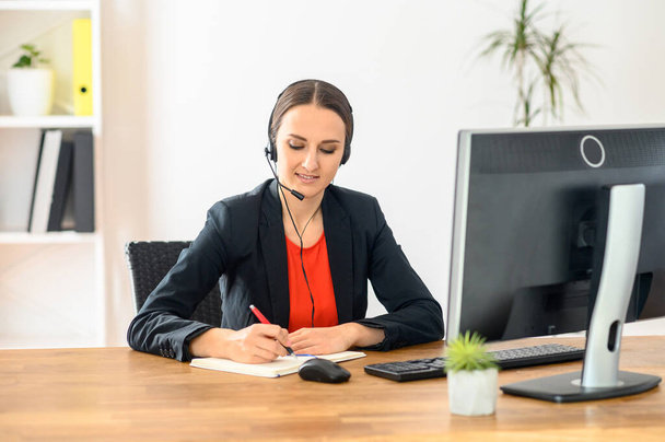 Woman using headset and pc for work - Photo, Image
