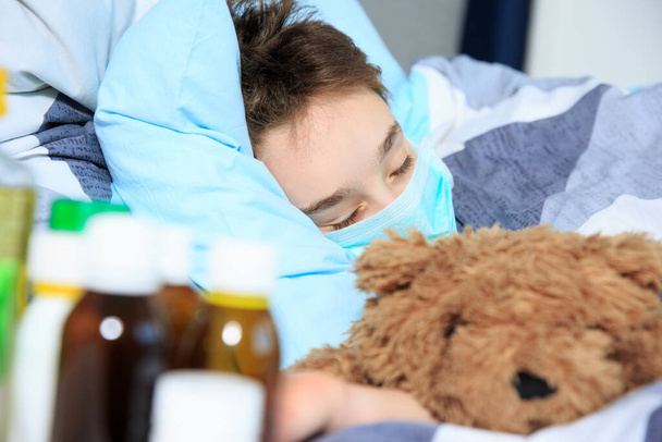 menino doente deitado na cama com um termômetro na boca
 - Foto, Imagem